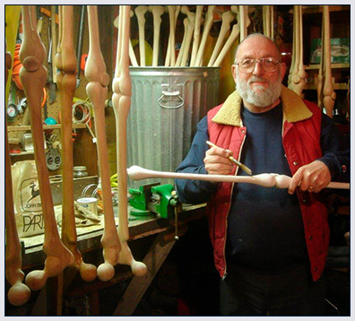 Bob in his workshop painting a hand carved cane.